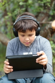 Teen boy in headphones with pad